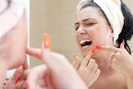 A woman picking her face showing one common mistake on How to Treat Melasma and Dark Spots on the Face